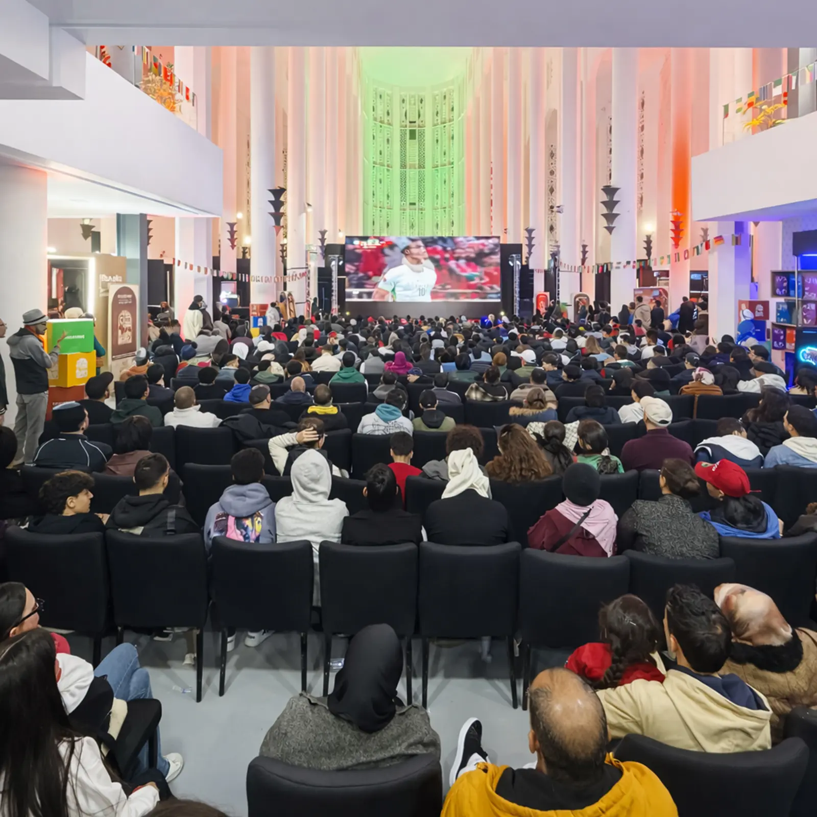 Espace de retransmission des matchs de la CAN 2025 à Casablanca, fanzone Ezone avec écran géant et public nombreux, aménagement événementiel réalisé par MG Corp.