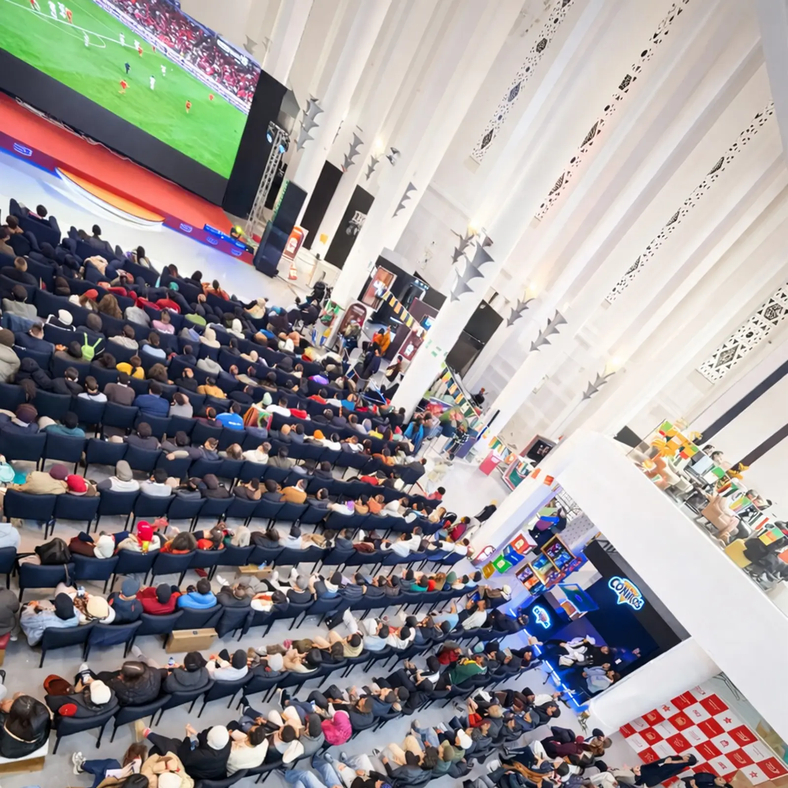 Espace de retransmission des matchs de la CAN 2025 à Casablanca, fanzone Ezone avec écran géant, gradins et public rassemblé pour suivre un match du Maroc, aménagement événementiel réalisé par MG Corp.