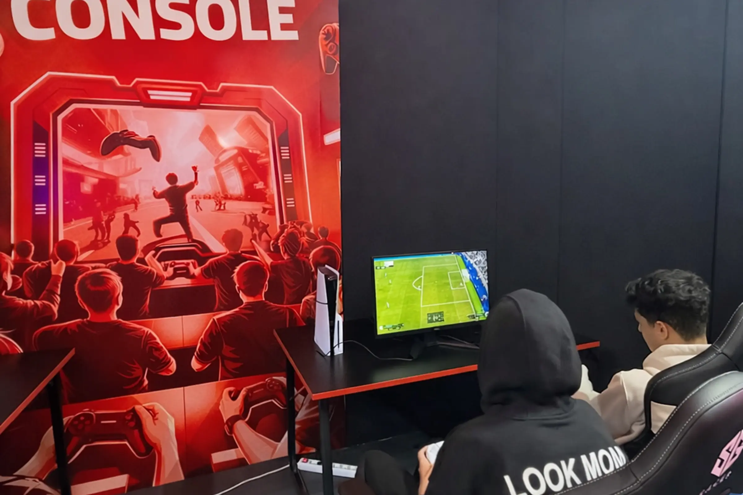 Stand console, espace gaming de la Fédération Royale Marocaine des Jeux Électroniques (FRMJE) dans l’eZone Fanzone à Casablanca pendant la CAN 2025, avec des joueurs e-sport en pleine compétition sur consoles.