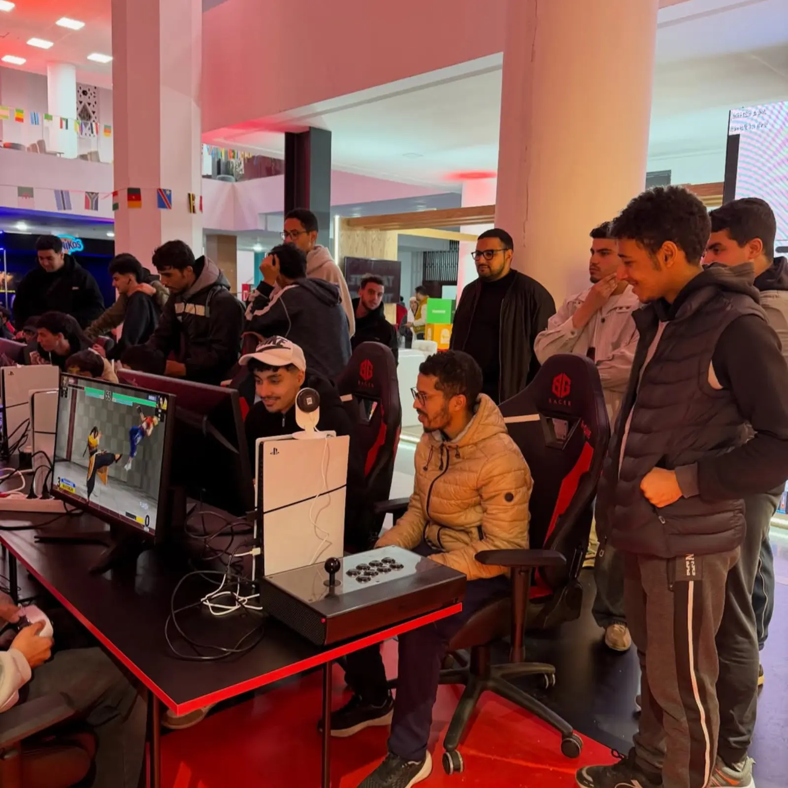 FRMJE stand in the eZone Fanzone in Casablanca during AFCON 2025, featuring esports players competing face-to-face on consoles surrounded by an engaged audience in a lively gaming space